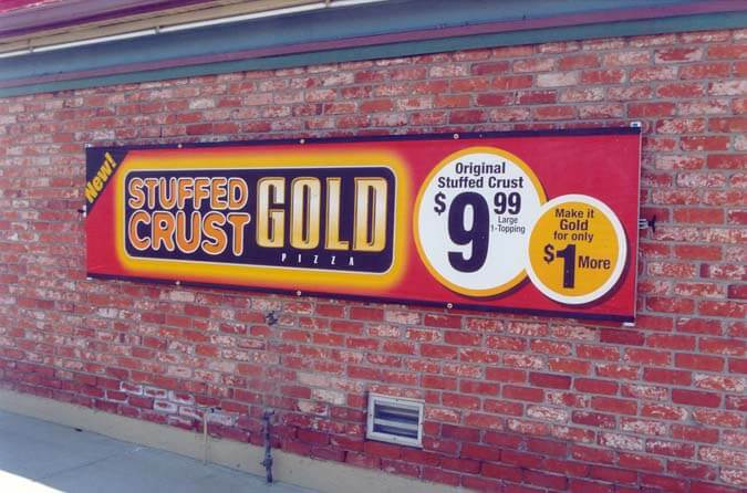 Mounted Banner Frames from Voxpop Marketing Systems exterior merchandising Mounted outdoor banner on brick wall for stuffed crust gold pizza