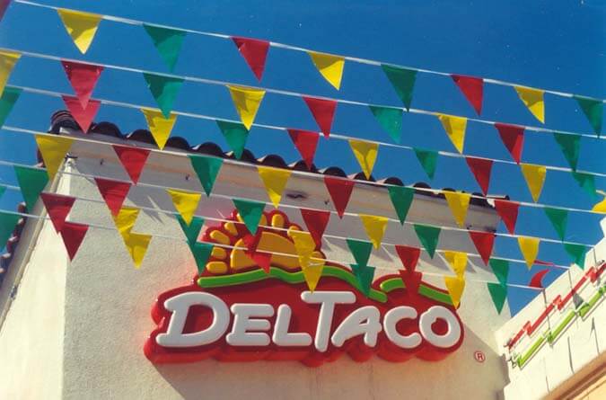 Outdoor displays using blade flags as exterior merchandising from Voxpop Marketing Systems Blade flags on pennant strings in front of Del Taco